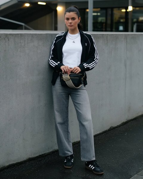 Junge Frau in Barrel-Jeans, Trainingsjacke und Sneakern